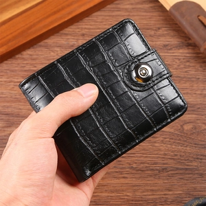 Close-up of a black crocodile pattern leather wallet with a secure metallic button closure