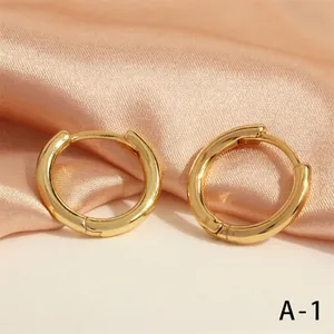 Minimalist 18K gold plated U-shaped geometric hoop earrings on elegant silk fabric