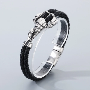 Detail of double-layer black woven leather bracelet with silver scorpion stainless steel clasp