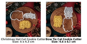 Detail of Christmas cat cookie cutters with finished biscuit on festive red background