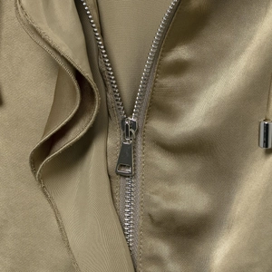 Cropped view of a trendy golden beige satin jacket with a premium silver metal zipper detail