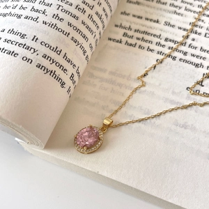 Elegant 925 silver gold necklace featuring pink oval gemstone on an open book background