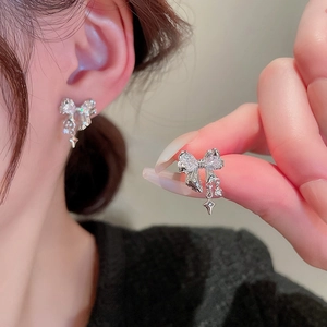 Elegant silver bow earrings with zircon star pendant in a stylish minimalist design