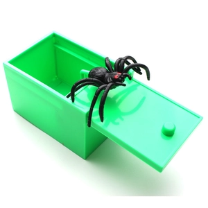 Detail shot of a green plastic prank box with a realistic black spider popping out