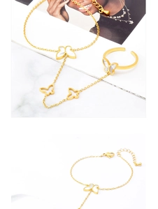 Détail de la gourmette main dorée et bague réglable avec incrustation papillon blanc