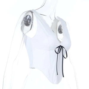 Detailaufnahme des weißen Spitzen-Camisoles mit schwarzer Satinschleife am V-Ausschnitt