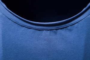 Macro shot of blue cotton T-shirt neckline with high-quality stitching detail