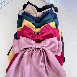 Elegant satin bow hair clips in multiple colors including pink, navy, and wine red