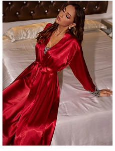 Detail view of red satin robe showing elegant black lace cuffs and luxurious silk texture