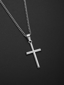 Détail du pendentif croix argentée avec chaîne gourmette classique sur fond sombre texturé