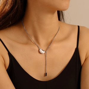 Minimalist silver steel necklace with bean pendant and black charm tassel on model