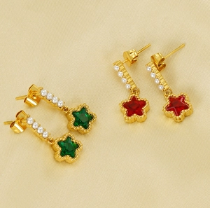 Detailed shot of star earrings with green and red stones and small faux pearls
