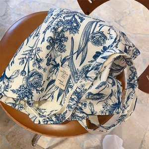 Detailed macro view of the botanical tie-dye print and brand label on a cotton tote bag