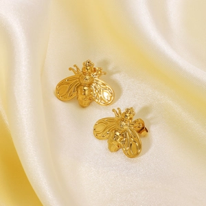 Elegant 18K gold-plated bee stud earrings displayed on premium yellow silk fabric