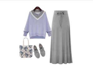Flat lay of purple V-neck knit sweater and grey high waist slit midi skirt with accessories