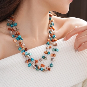 Detailed shot of multi-layer necklace with irregular colorful shell beads on a model
