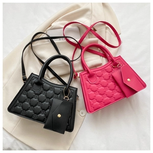 Detail of black and pink quilted leather bags with matching mini envelope charms