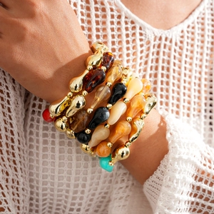 Bracelet bohème multicouche en perles acryliques avec détails dorés sur le poignet