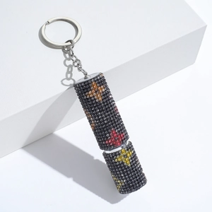 Detail of cylinder keychain with black rhinestones and colorful star patterns