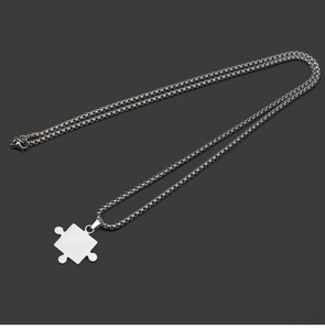 Titanium steel puzzle pendant couple necklaces with silver box chain set on grey background