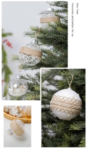 Close-up of clear Christmas ornaments with snowflakes and burlap bows on a tree