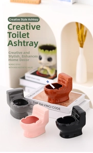Creative toilet-shaped ceramic ashtray available in multiple colors on books