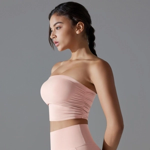 Detalle del top deportivo rosa sin tirantes con fruncido lateral y pantalones de yoga de cintura alta