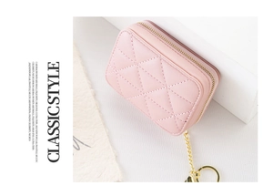 Pink quilted lipstick case with gold chain keychain and mirror on a soft background