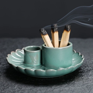 Ceramic palo santo holder in green glaze with dual slots and burning incense wood