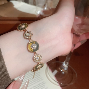 Nahaufnahme eines 18K vergoldeten Armbands mit Zirkon-Sonnendesign am Handgelenk