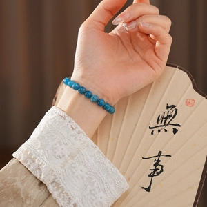 Detailed close-up of blue apatite crystal beaded bracelet with elegant lace sleeve and fan