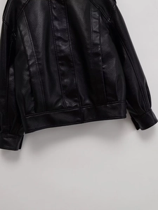 Gros plan détaillé sur la texture du cuir grainé et les coutures d'un blouson noir
