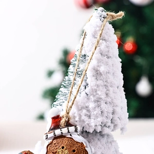 Detail of flocking snowy Christmas tree and gingerbread man ornament with hemp rope