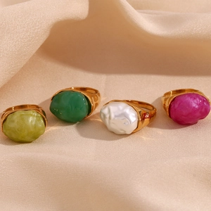 Close-up of four 18K gold plated rings with irregular acrylic stones in vibrant colors