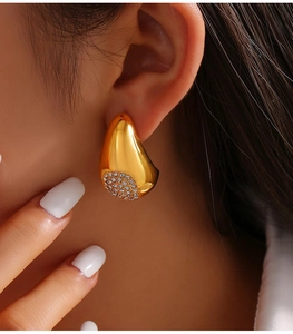 Vue rapprochée de la boucle d'oreille goutte d'or avec zircons sertis