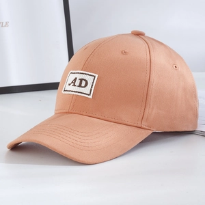 Close-up of light brown canvas baseball cap featuring AD letter embroidery detail