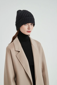 Detail shot of the black ribbed knit beanie texture and folded cuff style for winter