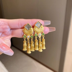 Detail of vintage gold diamond earrings with rhombus shape, grey stone and pearl tassels