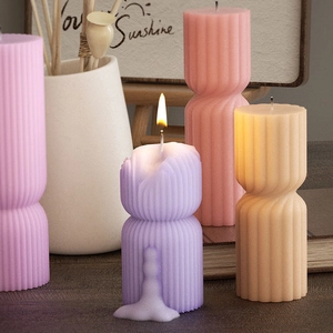 Vertical ribbed column scented candle in pastel tones with burning flame effect