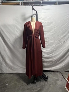 Detail view of burgundy V-neck maxi dress featuring waist twist knot and pleated texture