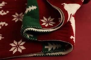 Macro shot of red knit scarf showing detailed reindeer and snowflake textures
