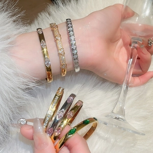 Macro detail of heart and oval zircon bracelets in gold and silver finish with fine crystals