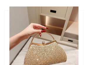 Detail of gold sequin evening clutch bag with sparkling diamond crown clasp and round metal handle