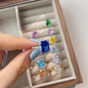 Close-up of radiant blue square-cut gemstone ring with detailed side pavé diamonds