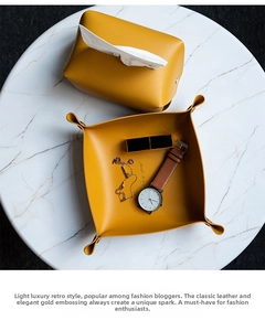 Macro shot of mustard yellow faux leather storage tray and tissue box with gold lettering