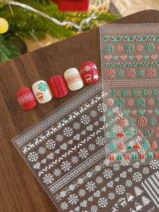 Detailed Christmas nail stickers featuring red reindeer and white snowflake patterns