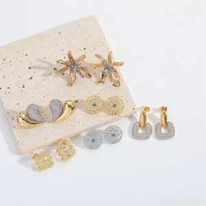 Elegant heart and starfish earrings set with zircon stones on stylish travertine display