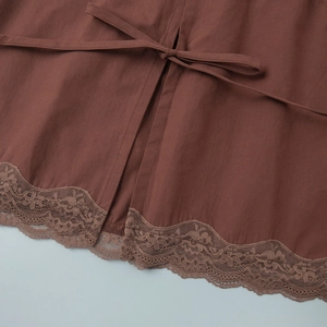 Close-up of brown skirt waist with tie-up detail and intricate vintage floral lace trim