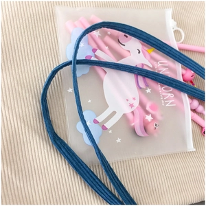 Close-up of translucent unicorn pencil case with blue lanyard and pink pens inside