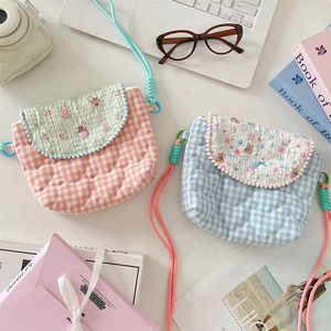 Flat lay of pink and blue quilted crossbody bags with heart patterns and floral details